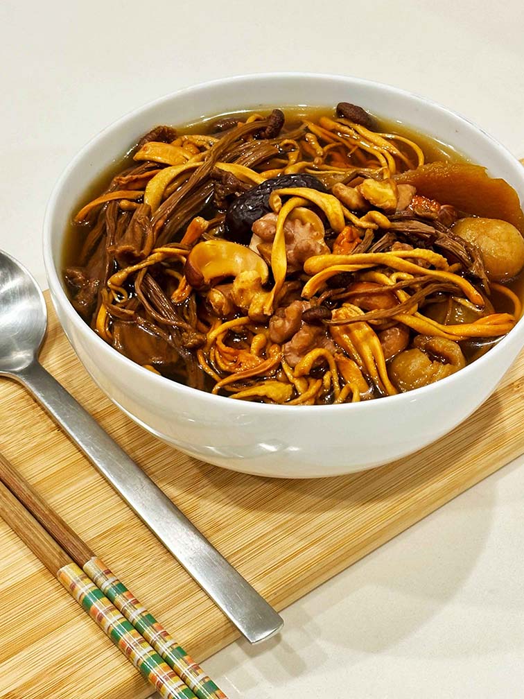 Close-up of prepared Immunity Strength Soup in a bowl - 茶樹菇蟲草花補氣湯 offering immune system enhancement, blood nourishment benefits with natural ingredients. 一碗已煮好的茶樹菇蟲草花補氣湯特寫,提供増免疫力功效,採用天然食材。