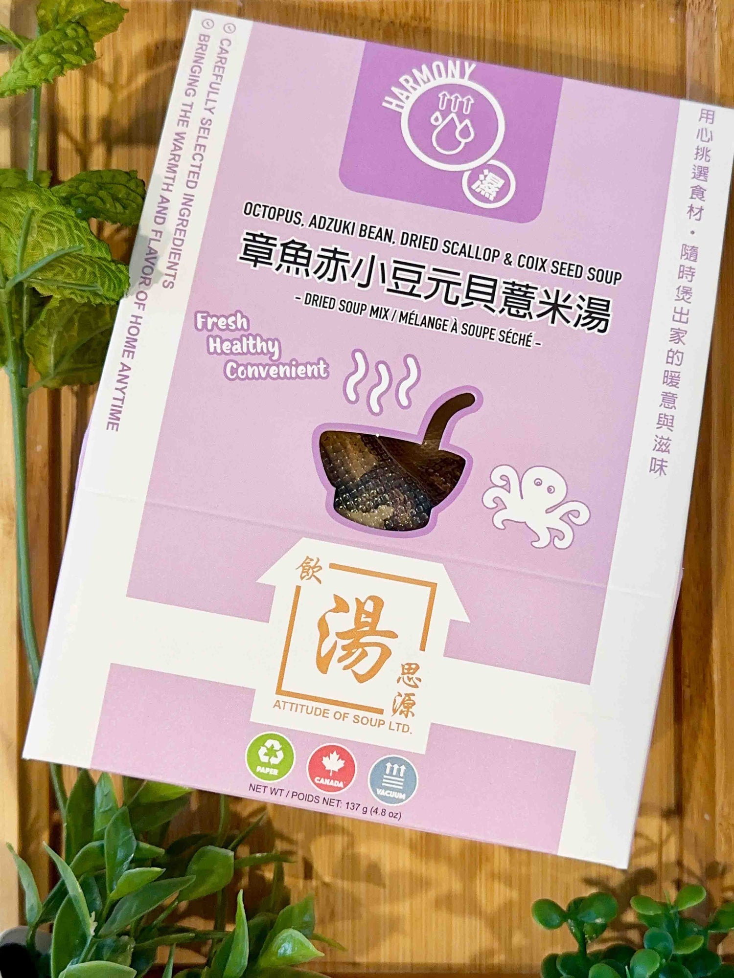 Harmony Series – Octopus, Adzuki Bean, Dried Scallop & Coix Seed Soup pack displayed with fresh greenery on wooden surface. 飲湯思源 HARMONY 系列章魚赤小豆元貝薏米湯，木質背景配上綠植，健康清新感十足。
