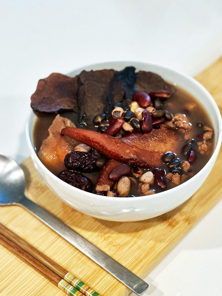 Close-up of prepared Hair Care Soup in a bowl - 何首烏黑豆養顏湯 offering the kidneys, promotes dark hair and beauty benefits with natural ingredients. 一碗已煮好的何首烏黑豆養顏湯特寫，提供改善白髮功效，採用天然食材。