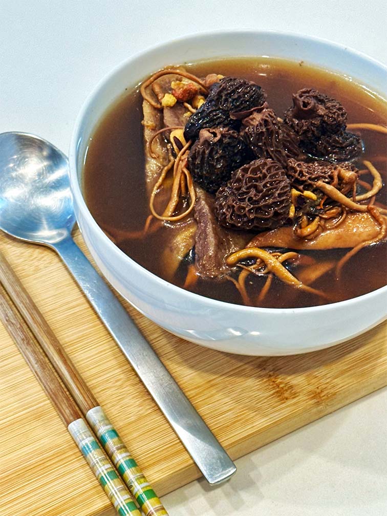 Cooked Vital Defense Soup in bowl – herbal soup with visible morel mushrooms and cordyceps flower 已煮好羊肚菌蟲草花滋補湯 – 湯碗中可見羊肚菌與蟲草花，滋補美味