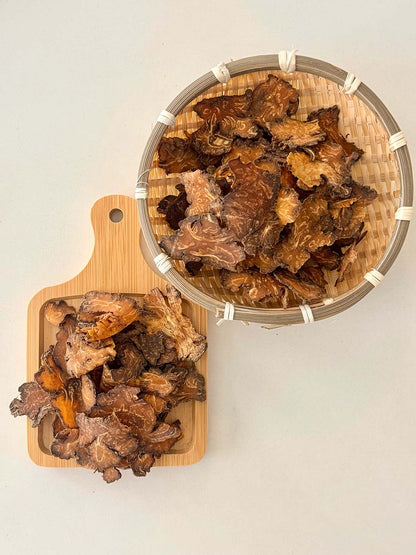 Dried Chuan Xiong Szechuan lovage rhizome slices displayed in a bamboo basket and wooden tray 乾製川芎根莖片，盛載於竹籃及木製托盤上展示
