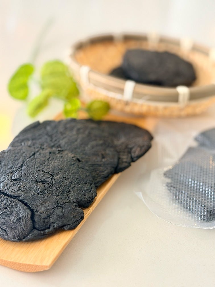 Close-up of dark Shu Di Huang Prepared Rehmannia Root with basket and vacuum-sealed pack 深色熟地炮製地黃根特寫，配以竹籃及真空密封包裝