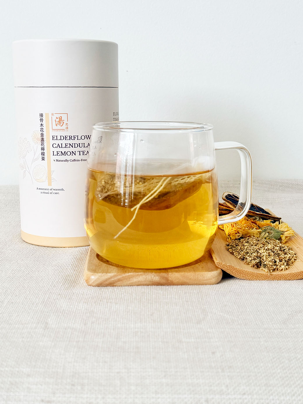 Elderflower Calendula Lemon Flower Tea with hot brewed caffeine-free flower tea and dried elderflower, calendula, and lemon ingredients 接骨木花金盞花檸檬茶配熱泡零咖啡因花茶，以及接骨木花、金盞花和檸檬片材料